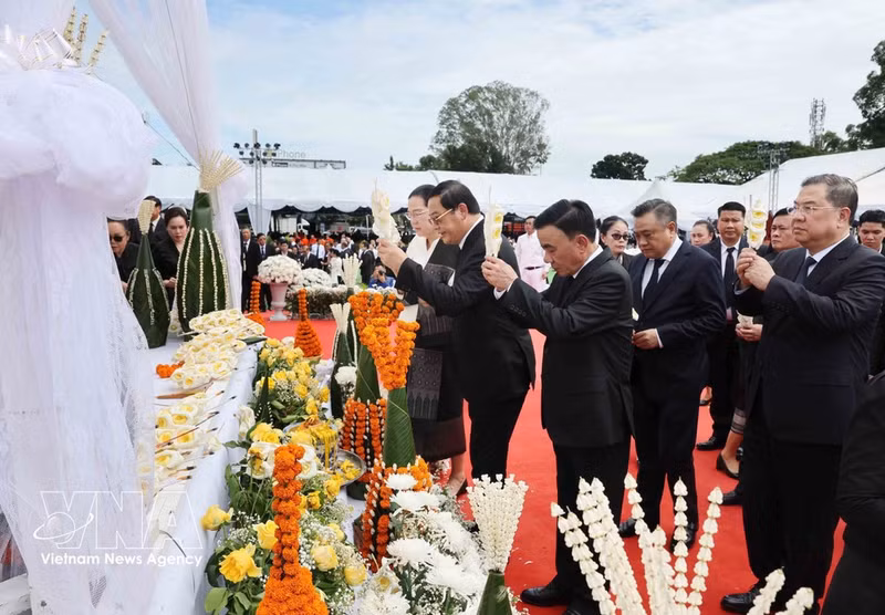 El miembro del Buró Político e integrante permanente del Secretariado del Comité Central del Partido Comunista de Vietnam, Tran Cam Tu, al frente de una delegación nacional de alto nivel, rinde homenaje póstumo a Xaysomphone Phomvihane, miembro del Buró Político del PPRL y presidente de la Asamblea Nacional de Laos. (Foto: VNA)