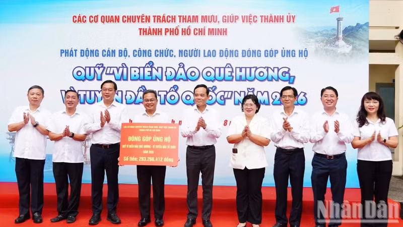 El secretario del Comité del Partido Comunista de Vietnam en Ciudad Ho Chi Minh, Tran Luu Quang, junto con miembros permanentes de esta instancia y dirigentes de sus órganos especializados de asesoramiento y apoyo, entrega fondos al Fondo “Por los mares e islas de la Patria-Por la vanguardia de la Patria” de la ciudad en 2026. (Foto: VUONG LE)