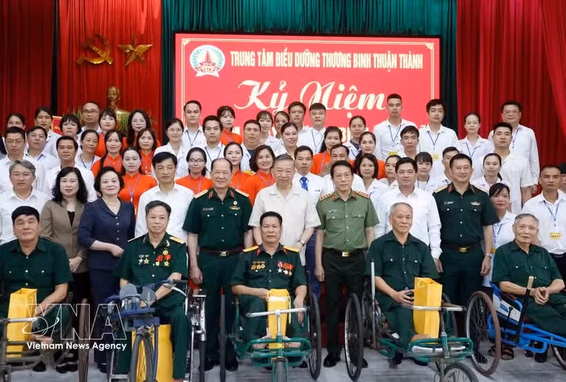 El secretario general del PCV y presidente del Estado, To Lam (centro, de pie, primera fila), posa para una foto grupal con el personal, los inválidos y los soldados enfermos en el Centro de Atención para Inválidos de Thuan Thanh. (Foto: VNA)