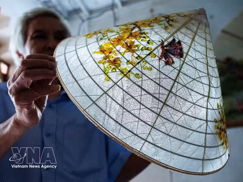El artesano Vo Ngoc Hung ha dedicado muchos años a investigar y experimentar para transformar las hojas de almendro silvestre, aparentemente sin valor, en singulares sombreros transparentes. (Foto: VNA)