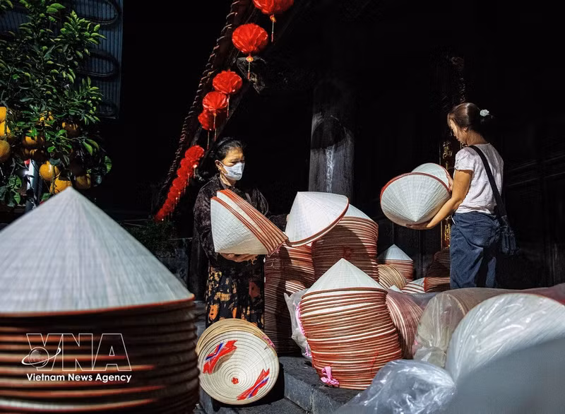 En el mercado, los aldeanos llevan montones de sombreros cónicos a la plaza del pueblo para venderlos. (Foto: VNA)