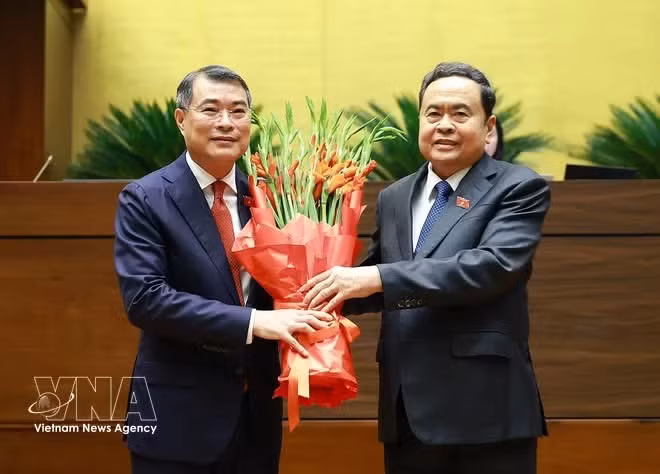 El presidente de la Asamblea Nacional, Tran Thanh Man, entrega flores para felicitar al primer ministro Le Minh Hung (izquierda). (Foto: VNA)