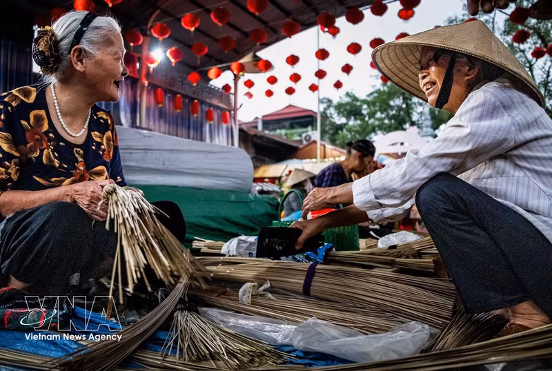 El mercado de sombreros de la aldea de Chuong no es solo un lugar para comprar y vender, sino también un espacio para reunirse, charlar y preservar las costumbres y tradiciones familiares de la gente local. (Foto: VNA)