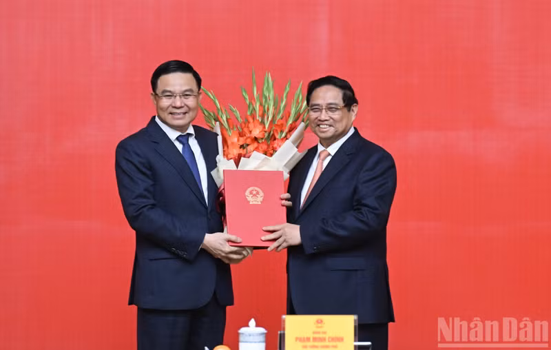 El primer ministro de Vietnam, Pham Minh Chinh, entrega la decisión de nombrar a Le Manh Hung, como ministro interino de Industria y Comercio.
