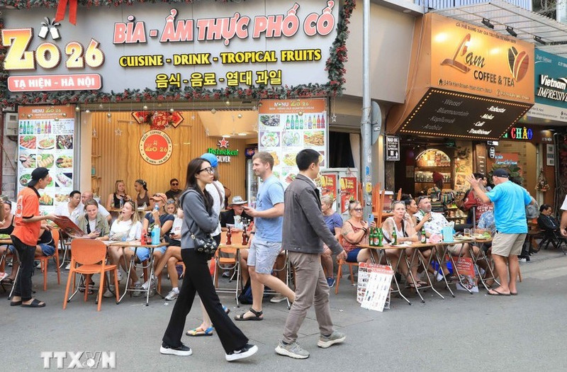 Turistas extranjeros disfrutan de la gastronomía en la calle Ta Hien, Hanói. (Foto: VNA)