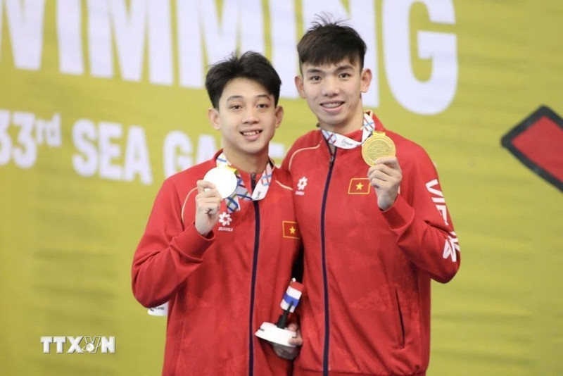 Los nadadores Nguyen Huy Hoang y Mai Tran Tuan Anh en el podio recibiendo sus medallas. (Foto: VNA)