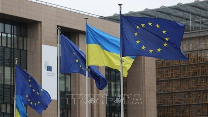 La bandera de la Unión Europea y la bandera de Ucrania en la sede de la Comisión Europea en Bruselas, Bélgica. (Foto: Xinhua/TTXVN)