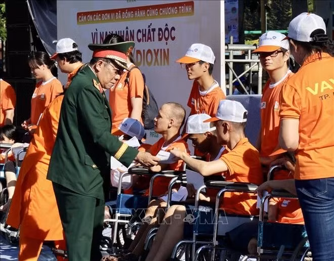 Líderes de la Asociación de Víctimas del Agente Naranja/Dioxina entregan regalos a los víctimas de la sustancia química tóxica durante el evento. (Foto: VNA)