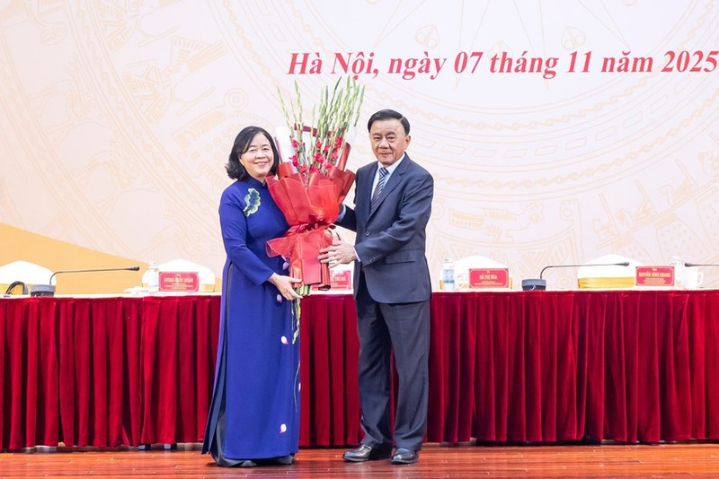 El miembro del Buró Político y permanente del Secretariado del Comité Central del Partido Comunista de Vietnam (PCV), Tran Cam Tu, entrega flores para felicitar a Bui Thi Minh Hoai, nueva presidenta del Frente de la Patria. (Foto: VNA)