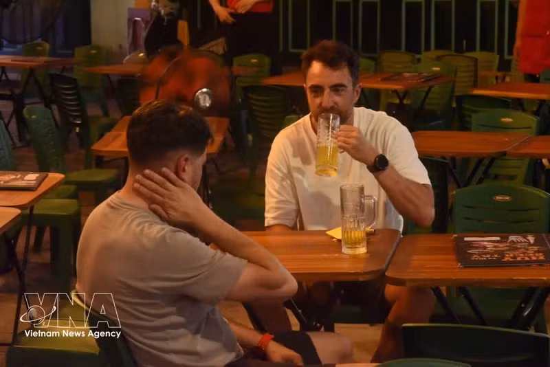 Los turistas disfrutan de la cerveza en la calle Ta Hien. (Foto: VNA)