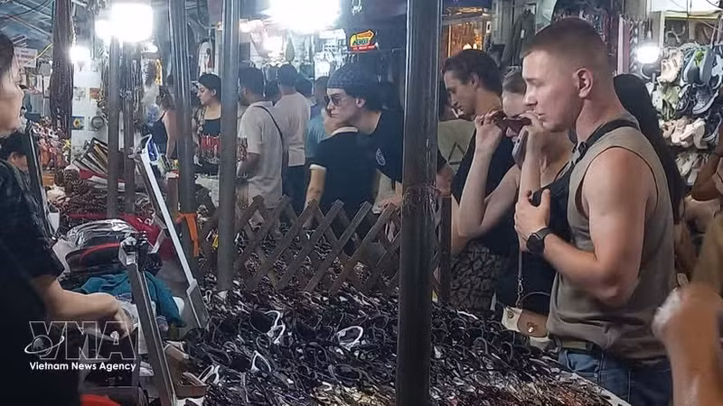 A los turistas internacionales les encanta comprar recuerdos en el mercado nocturno del Barrio Antiguo de Hanói. (Foto: VNA)