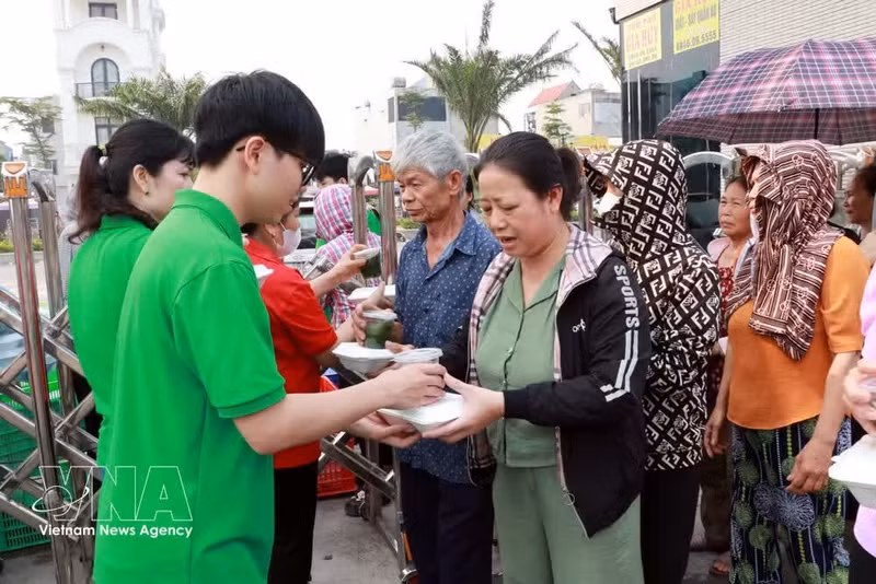 Estudiantes de la Escuela Secundaria Nguyen Khuyen (barrio Nam Dinh) entregan raciones de comida a pacientes. (Foto: VNA)