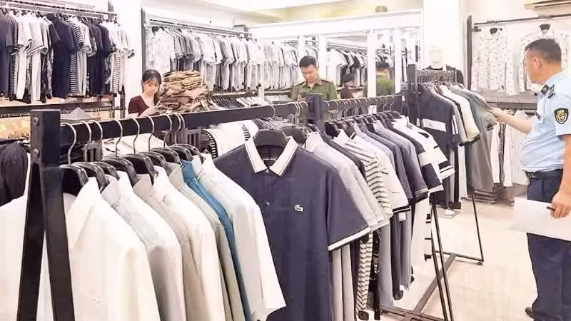 Las autoridades inspeccionan una tienda de moda que vende productos falsificados de marcas internacionales en el barrio de Tay Tuu, Hanói. (Foto: Tuan Ngoc)