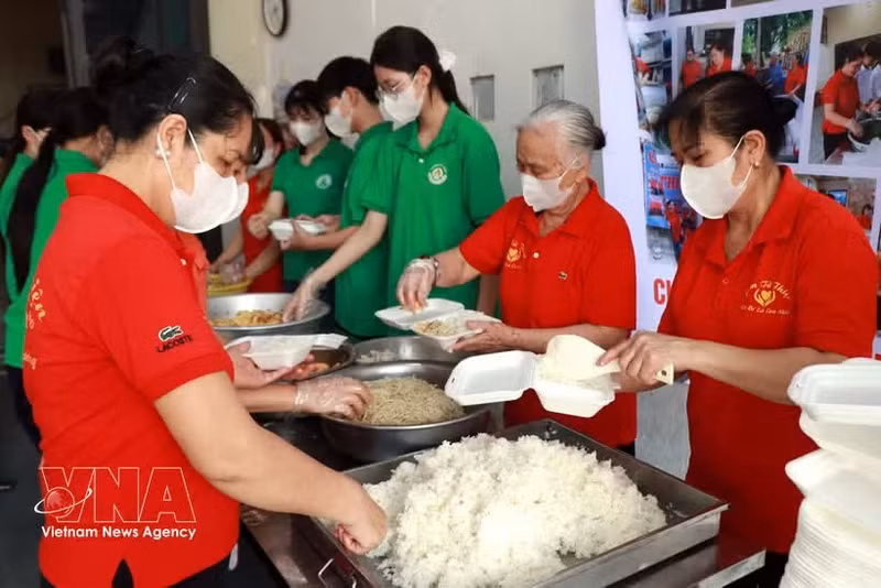 Los miembros de la Asociación de Comidas Solidarias y estudiantes de la escuela secundaria Nguyen Khuyen (barrio Nam Dinh) preparan raciones de comida gratuitas para entregar a los pacientes. (Foto: VNA)