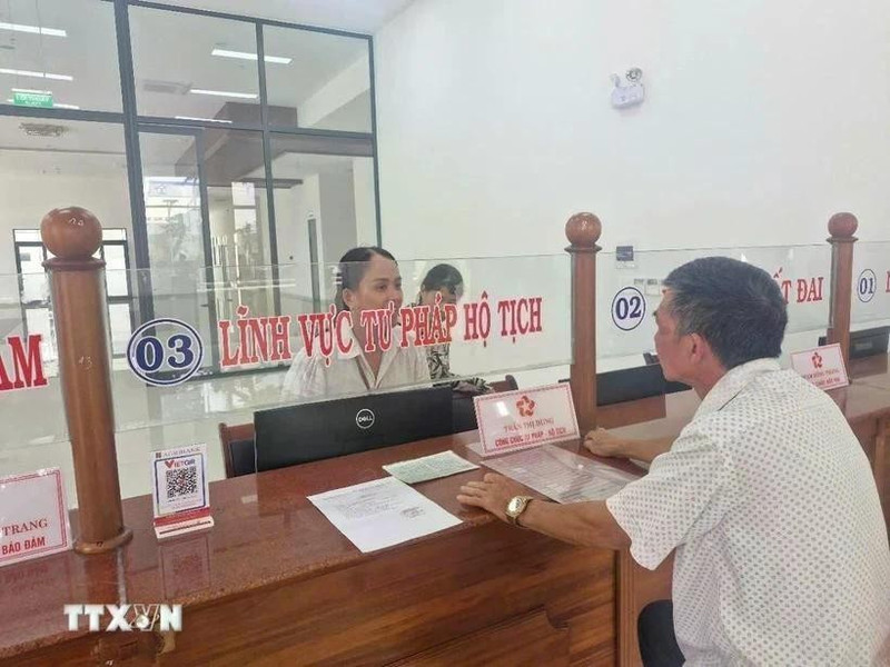 Las personas hacen trámites administrativos en el día del inicio de la prueba del gobierno de dos niveles en el distrito de Pleiku, Gia Lai. (Foto: VNA)