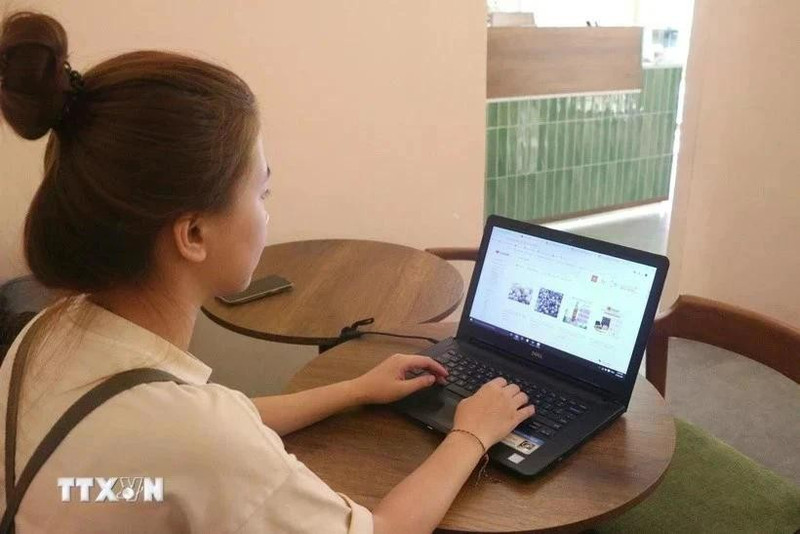 Una muchacha realiza sus compras en línea (Foto: VNA)