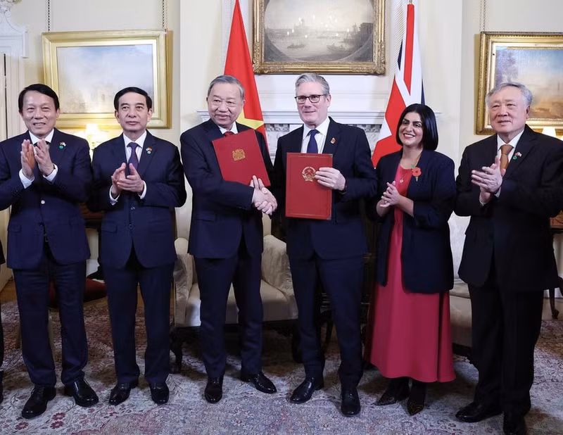 El secretario general del PCV, To Lam, y el primer ministro del Reino Unido, Keir Starmer, intercambian una declaración conjunta sobre la elevación de los nexos bilaterales al nivel de Asociación Estratégica Integral. (Foto: VNA)