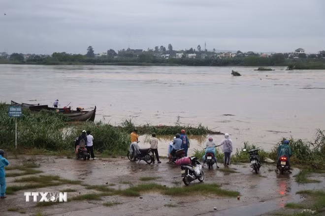 La gente vigila las inundaciones en el río Tra Khuc en Quang Ngai. (Foto: VNA)