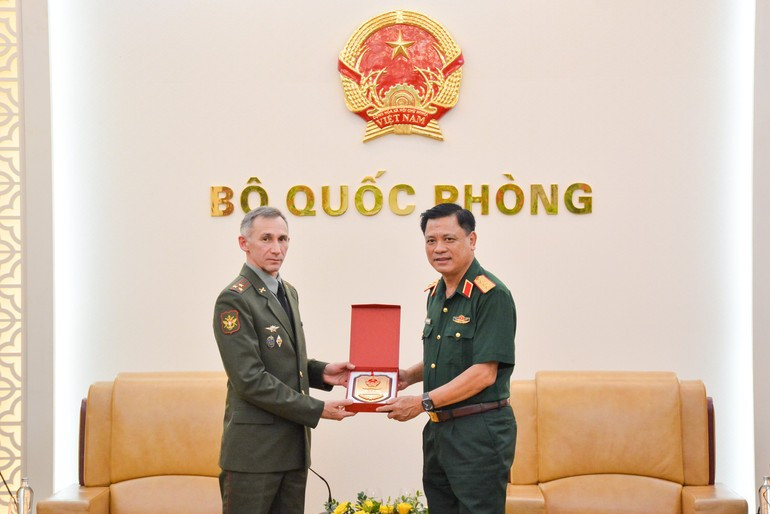 El coronel general Nguyen Truong Thang entrega un obsequio de recuerdo al coronel Belosludtsev Sergey Vladimirovich.