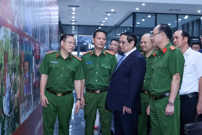 El primer ministro Pham Minh Chinh mira las fotos que resaltan la labor de identificación de los mártires sin nombre. (Foto: VNA)