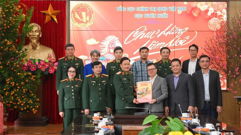 Le Quoc Minh, presidente-editor de Nhan Dan, entrega publicaciones del Tet de Nhan Dan a oficiales y soldados del Departamento de Propaganda y Educación, del Departamento General de Política del Ejército Popular de Vietnam.