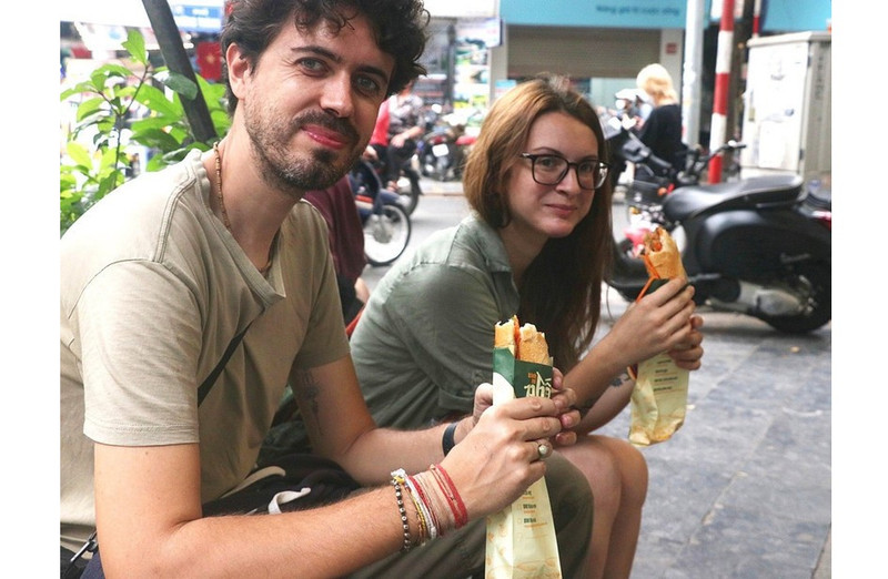 Visitantes internacionales se deleitan con la comida callejera de Hanói. (Foto: VNA)