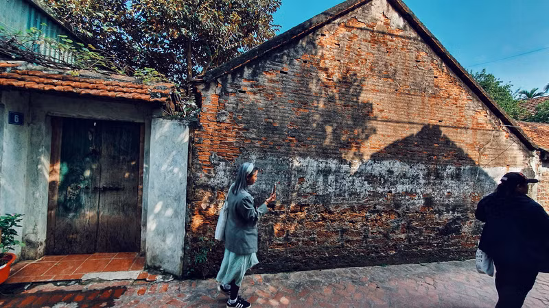 Los turistas visitan a la aldea en días previos del Tet.