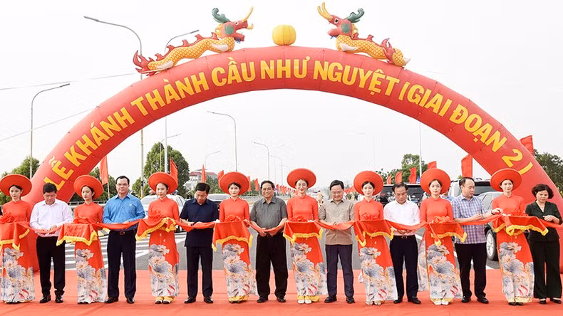 El primer ministro Pham Minh Chinh y los delegados cortan la cinta para inaugurar la segunda fase del puente Nhu Nguyet.