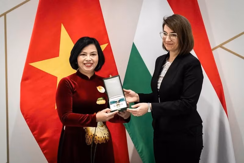La secretaria de Estado de Relaciones Bilaterales del Ministerio de Asuntos Exteriores y Comercio Exterior de Hungría, Illés Boglárka, entrega la Cruz de la categoría de Oficial de la Orden del Mérito a la embajadora vietnamita en Budapest, Nguyen Thi Bich Thao. (Foto: VNA)
