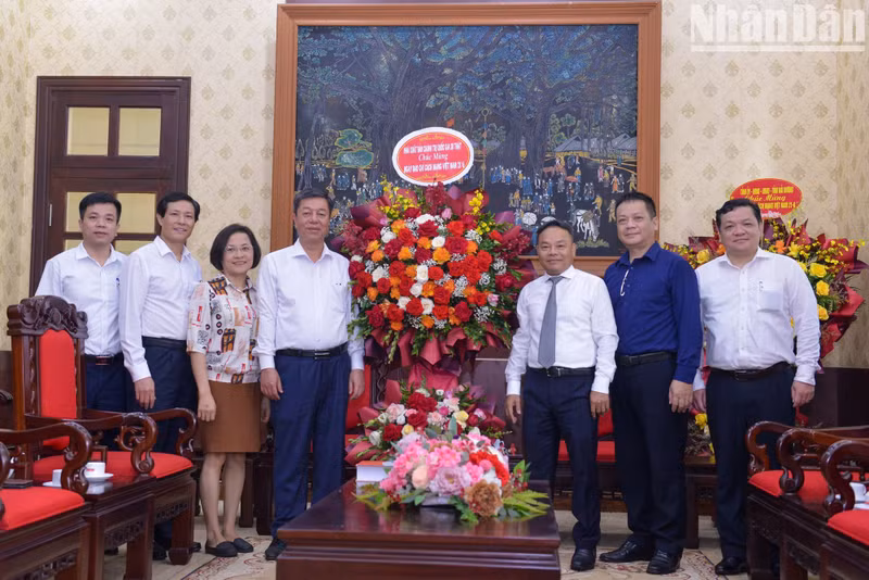 Vu Trong Lam, director y editor en jefe de la Editorial Política Nacional Su That (La Verdad), entrega flores para felicitar a Nhan Dan.