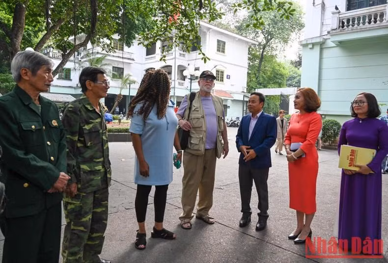 El redactor subjefe del diario Nhan Dan Dinh Nhu Hoan conversa con Steve Edmunds y los delegados.