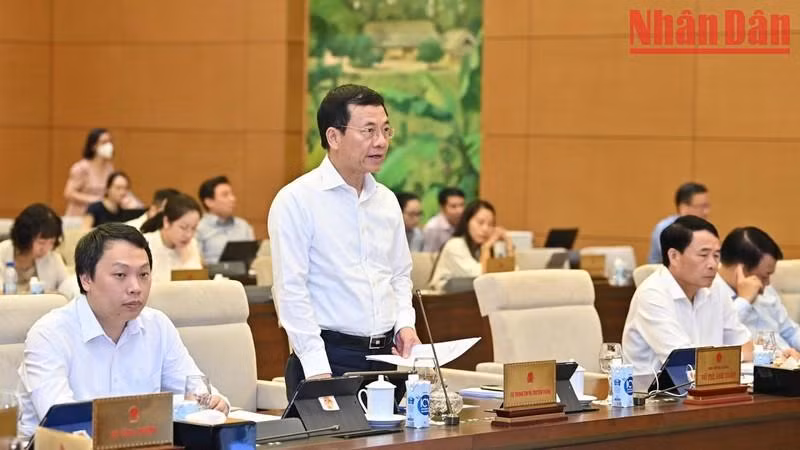 El ministro de Información y Comunicación, Nguyen Manh Hung, presenta un informe en la cita.
