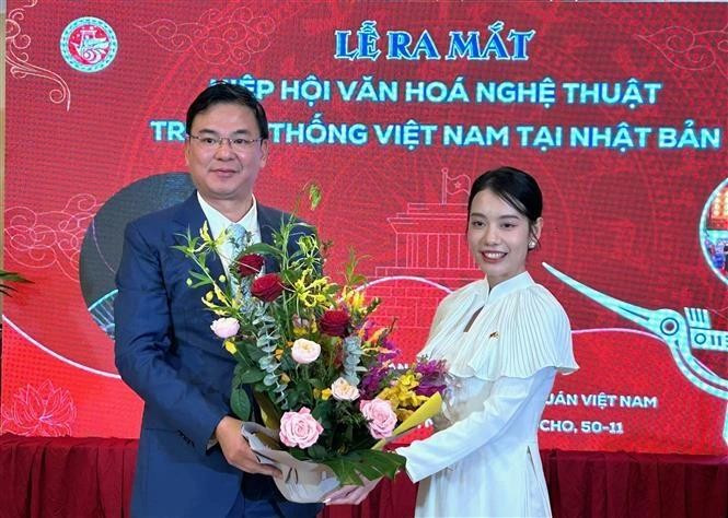 El embajador de Vietnam en Japón, Pham Quang Hieu, entrega flores a la presidenta de la asociación de cultura y arte tradicional vietnamita en Japón, Do Khanh Han. (Foto: VNA)
