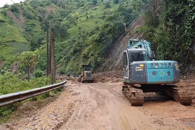 Las excavadoras movilizadas a un punto del deslizamiento de tierra en la carretera de la comuna de Khao Mang. (Fotografía: VNA)