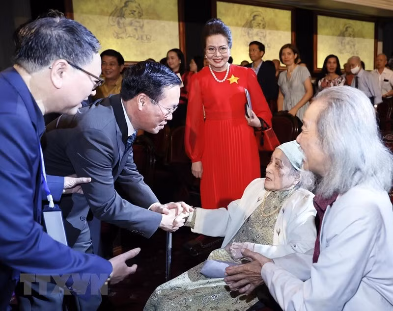 El presidente Vo Van Thuong saluda a Nghiem Thuy Bang, esposa del músico Van Cao.