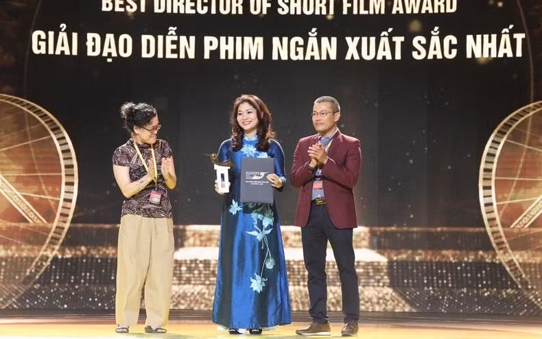 La jefa del Departamento de Cooperación Internacional del Ministerio de Cultura, Deportes y Turismo, Nguyen Phuong Hoa, recibe el premio al Mejor Director de Cortometraje en representación del nepalí Surya Shahi por la película "Wheels on the bus" (Ruedas en el bus).