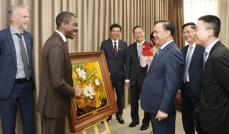 El secretario del Comité del Partido Comunista de Vietnam en Hanói, Dinh Tien Dung, recibe al Lazarre Eloundou, director del Centro del Patrimonio Mundial.