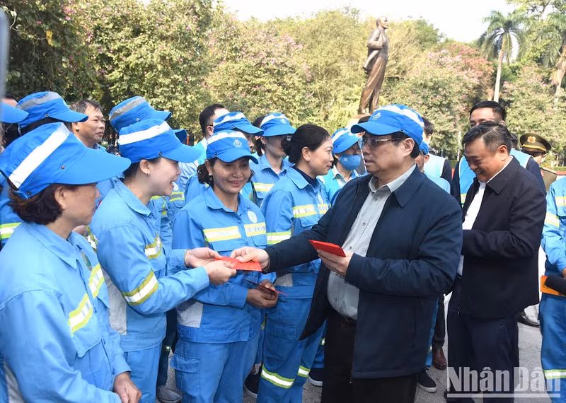 Minh Chinh regala dinero para buena suerte a los trabajadores.