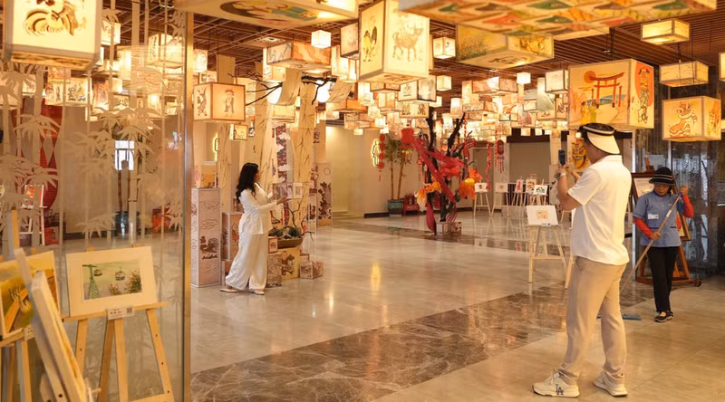 El espacio de exhibición de arte popular en la montaña Ba Den, decorado con faroles pintados a mano y cuadros tradicionales, cautiva a los visitantes que buscan capturar recuerdos fotográficos. El espacio de exhibición de arte popular en la montaña Ba Den, decorado con faroles pintados a mano y cuadros tradicionales, cautiva a los visitantes que buscan capturar recuerdos fotográficos.