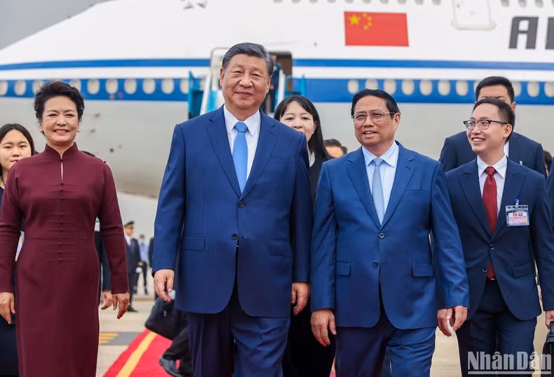 Pham Minh Chinh, miembro del Buró Político y primer ministro de Vietnam, da la bienvenida a Xi Jinping, secretario general del PCCh y presidente de China, en el Aeropuerto Internacional de Noi Bai.