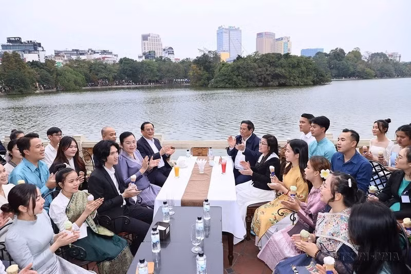 El primer ministro Pham Minh Chinh y su esposa, el premier Sonexay Siphandone y su esposa, junto con los estudiantes, cantan la canción de solidaridad entre Vietnam y Laos en el espacio cultural e histórico del lago Hoan Kiem (7 de enero de 2024).