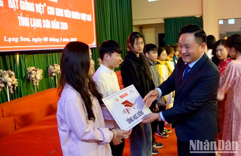 Phan Van Hung, subjefe de redacción del periódico Nhan Dan y presidente del Fondo de Semillas de Vietnam, entrega becas a los estudiantes.