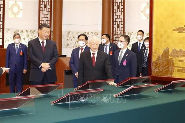 El secretario general del PCV, Nguyen Phu Trong, y el secretario general del PCCh y presidente de China, Xi Jinping, aprecian los documentos de cooperación firmados. (Fotografía: VNA)