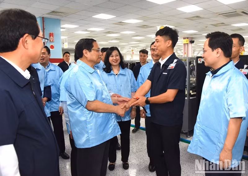 El primer ministro Pham Minh Chinh anima a empleados de la fábrica.