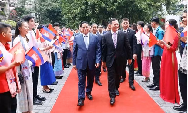 El primer ministro de Camboya, Samdech Moha Bovor Thipadei Hun Manet, y el premier anfitrión, Pham Minh Chinh, sostienen un intercambio con maestros y estudiantes de la Universidad de Comercio Exterior de Vietnam.(Foto: VNA)