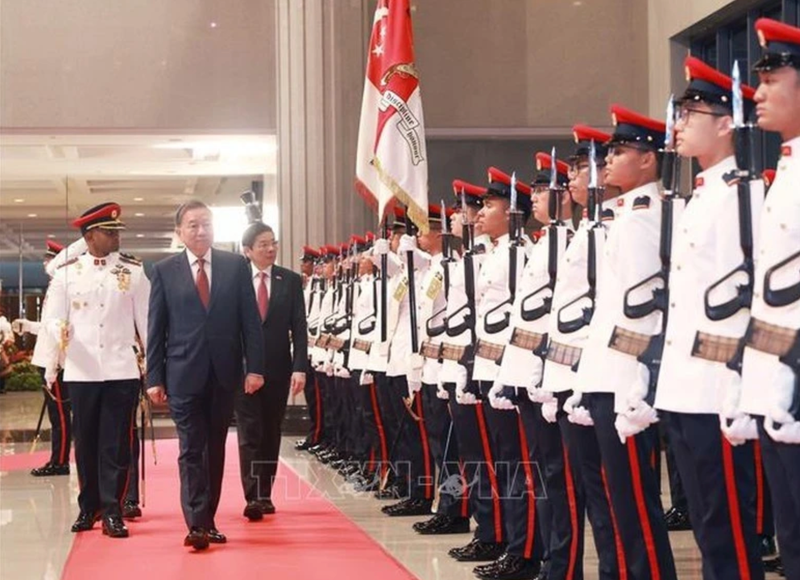 El secretario general del Partido Comunista de Vietnam, To Lam, y el primer ministro de Singapur, Lawrence Wong, pasan revista a la guardia de honor, con motivo de la visita del dirigente vietnamita a la nación insular (Foto. VNA)