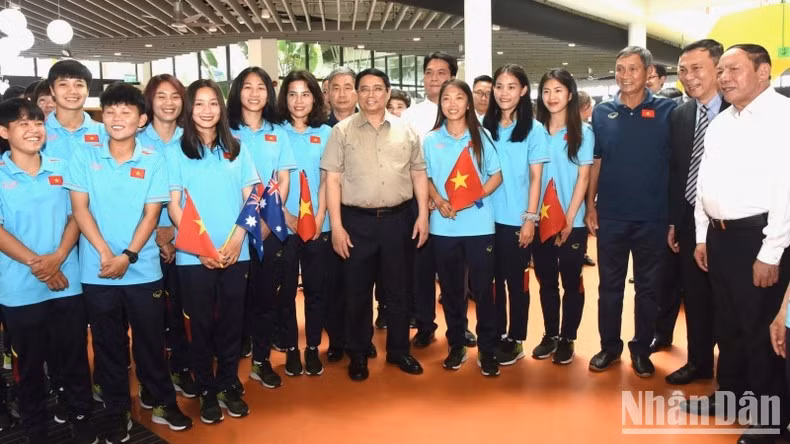 El primer ministro Pham Minh Chinh y el cuerpo técnico y las jugadoras de la selección vietnamita de fútbol femenino.