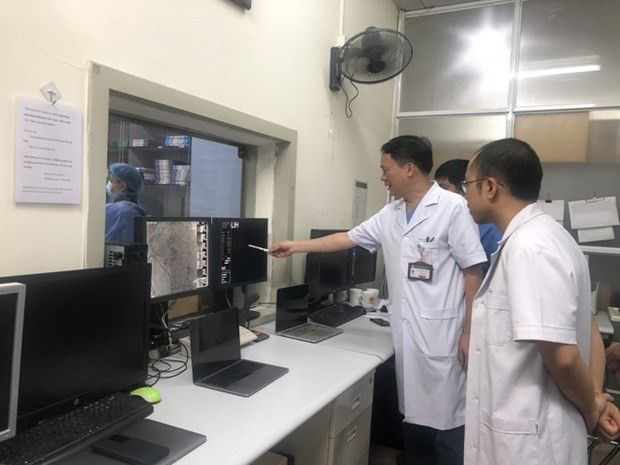 Los médicos evalúan un caso antes de la intervención. (Fotografía: VNA)