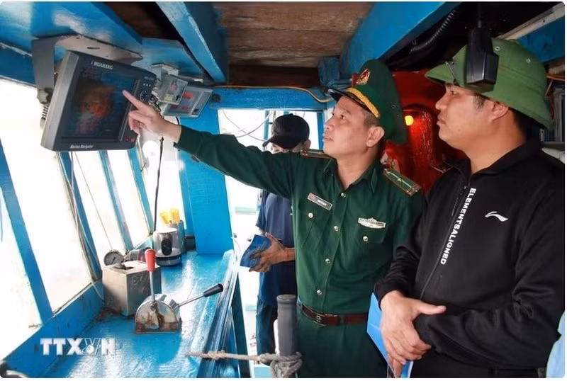 Un oficial de la guardia fronteriza revisa los dispositivos de vigilancia en un barco pesquero (Foto: VNA)