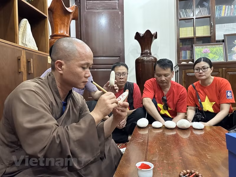 El venerable Thich Nhuan Dat, abad de la Pagoda de Truong Sa Lon, entrega letras a las personas que visitan Truong Sa.
